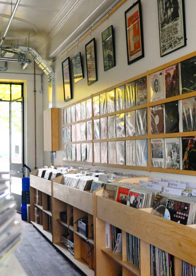 Racks of records organised and on display in wooden shelves