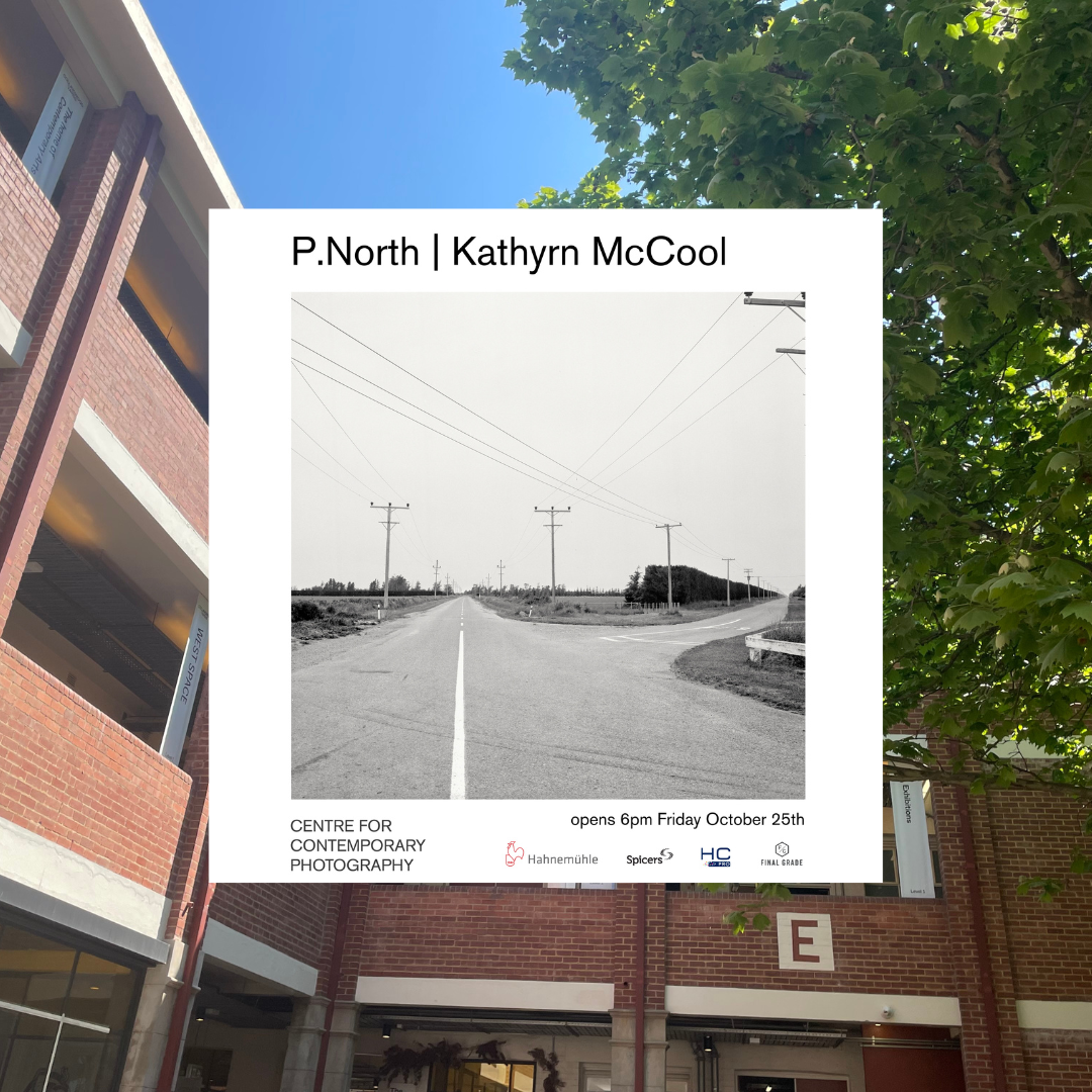 A black and white photo of a rural intersection. Three powerlines almost symmetrically at the very centre at the horizon. The title of the work, 'P.North' above the image alongside the photographer's name, Kathyrn McCool. 